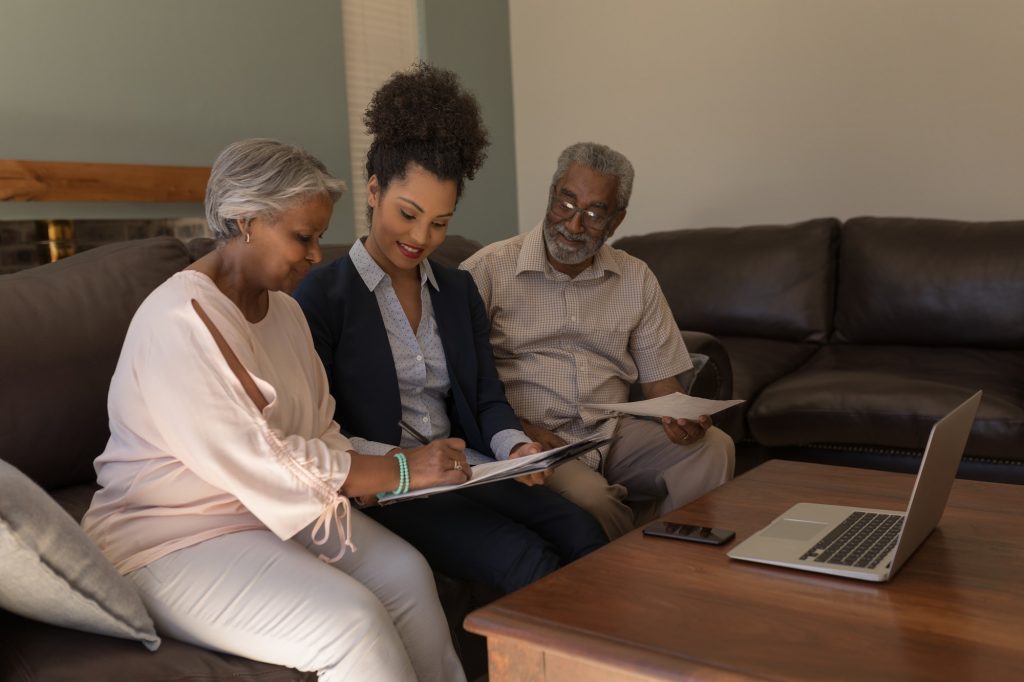 Senior couple signing property contract with real estate agent